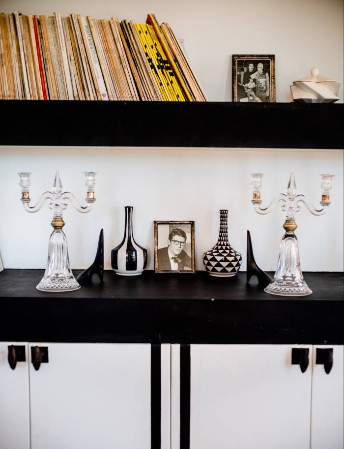 1930s candelabras, 1960s Carl Auböck black metal bookends and handmade ceramic vases from the Atelier Mayer studio flanking a photograph of Yves Saint Laurent, with whom Haid worked in the 1990s