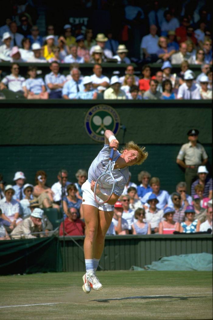 A young Boris Becker in tennis whites, stretches to hit the ball