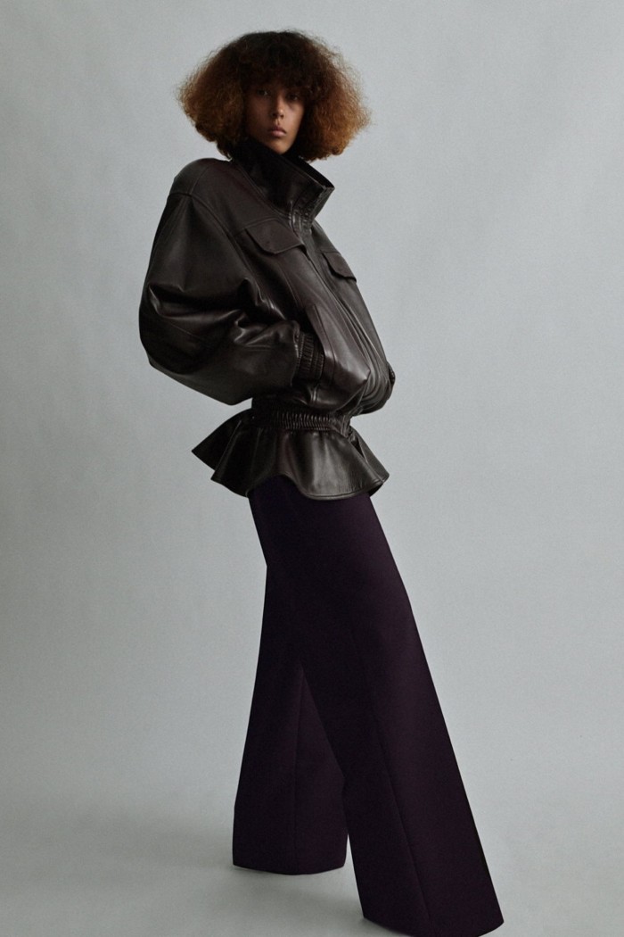 A model in leather bomber jacket with wide leg trousers