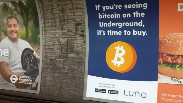 An advert reading ‘If you’re seeing bitcoin on the Underground, it’s time to buy’ on the London Underground
