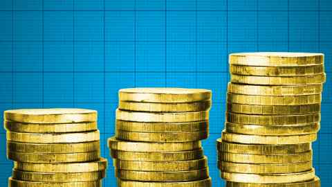 Three piles of gold coins against a background of blue block graph paper