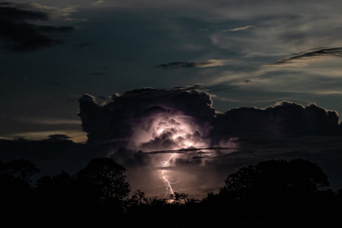 A flash of lightning illuminates the underside of dark cloud
