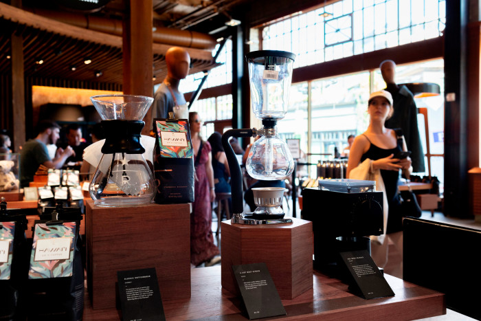 View of coffee grinding equipment and gleaming wooden counters and big glass windows at the Roastery