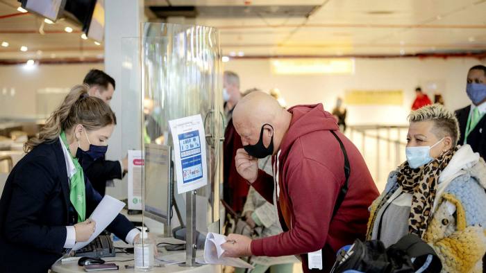 Travelers hand over PCR tests at the check-in counter at Schiphol in Amsterdam