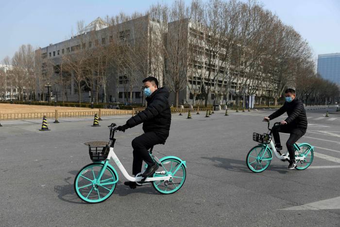 Two men bike around at Tsinghua University