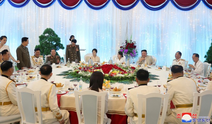 Kim Jong Un attends a navy celebration event wearing a beige suit