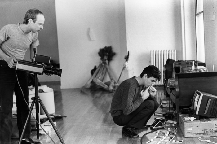 تظهر صورة في أوائل الثمانينيات إينو يحمل جهاز عرض في استوديو بينما ديفيد بيرن من Talking Heads جاثم بجانب شاشة