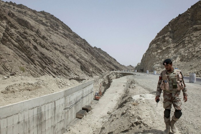 Un agent de sécurité observe la construction d'une autoroute près de Gwadar, au Pakistan, qui est en cours de construction dans le cadre de l'Initiative chinoise de la ceinture et de la route