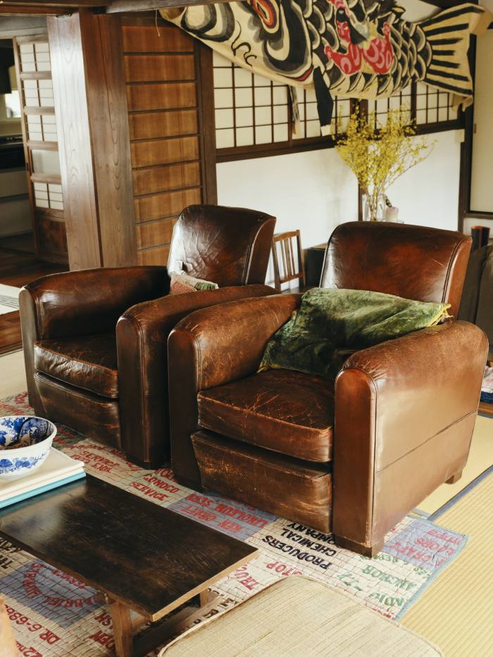 Two brown leather club chairs he found in France