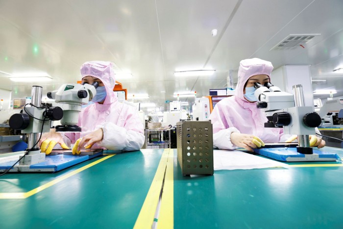 Technicians make microchips for export at a workshop in Sihong Economic Development Zone in Jiangsu province