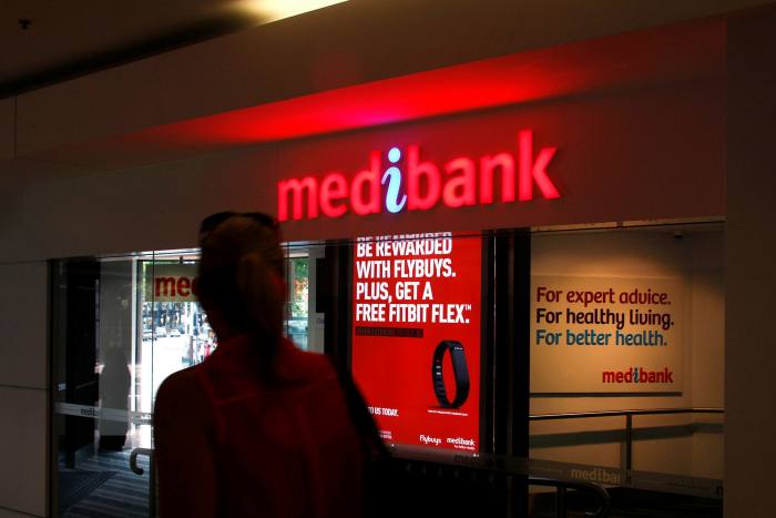 A woman walks past a branch of Medibank