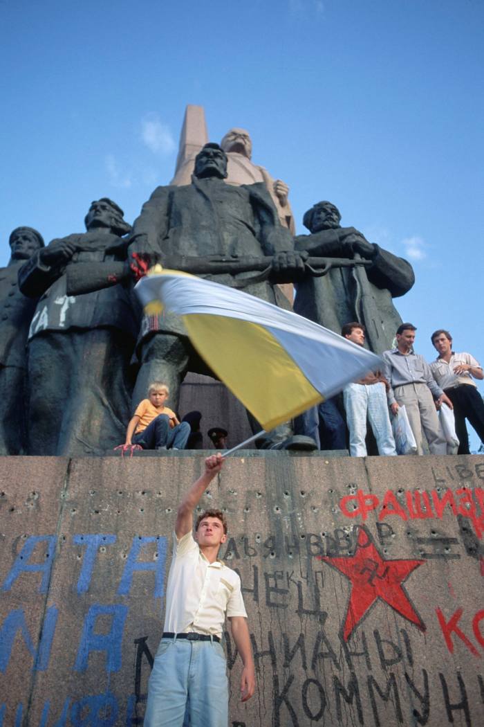 . . . and a young man stands on the graffitied base of a statue of Lenin, signalling a break with Soviet communism