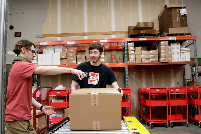 Target employees sort boxed items from online orders to be shipped out to customers at a Target store in Edison, New Jersey