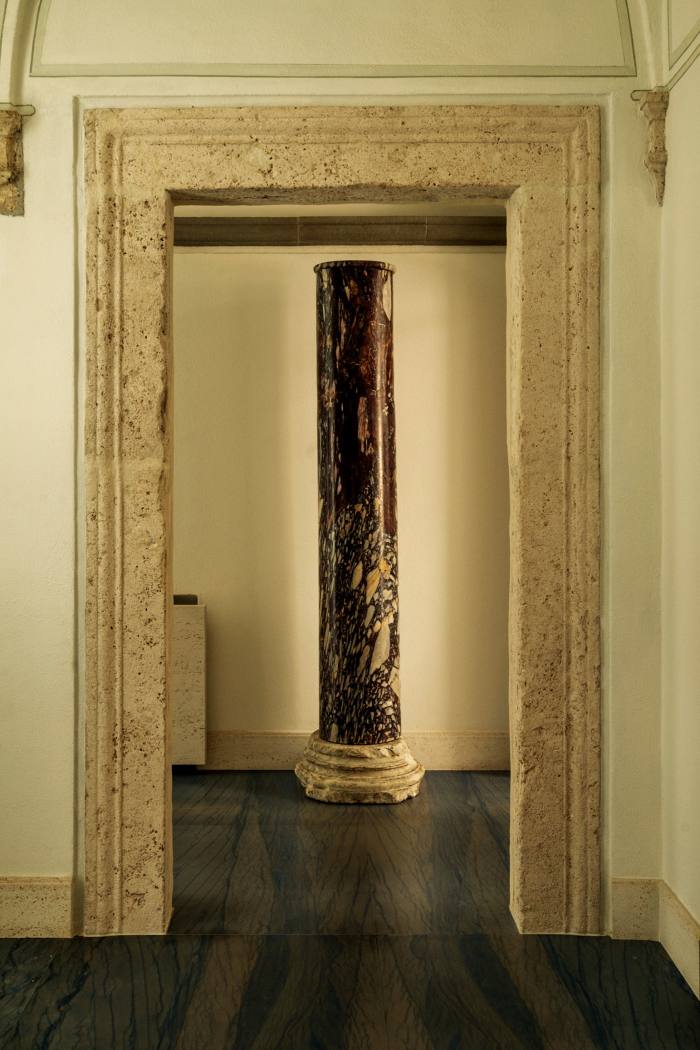 A travertine doorway from the 15th-century building frames a second-century breccia column
