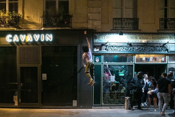 An activist from the On The Spot parkour team jumps to switch off shop lights in Paris