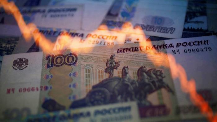 Rouble notes and a chart of the Russian currency versus the US dollar