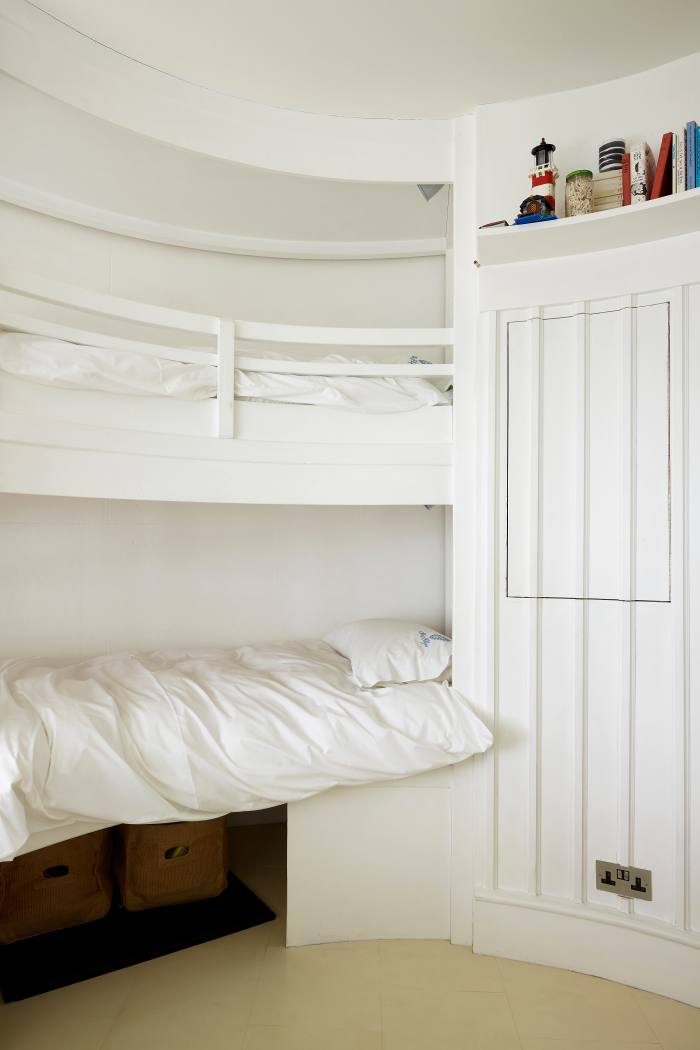 A white-painted bedroom in Winterton Lighthouse, with two built-in bunk beds