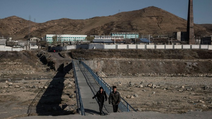 People cross a bridge near the town of Kimchaek on North Korea's northeast coast