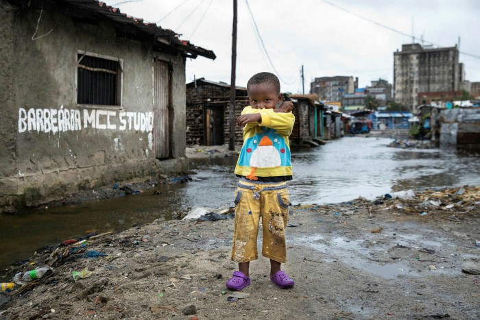 Rising waters behind a child in Beira, Mozambique. Younger generations are pushing for changes on climate policy