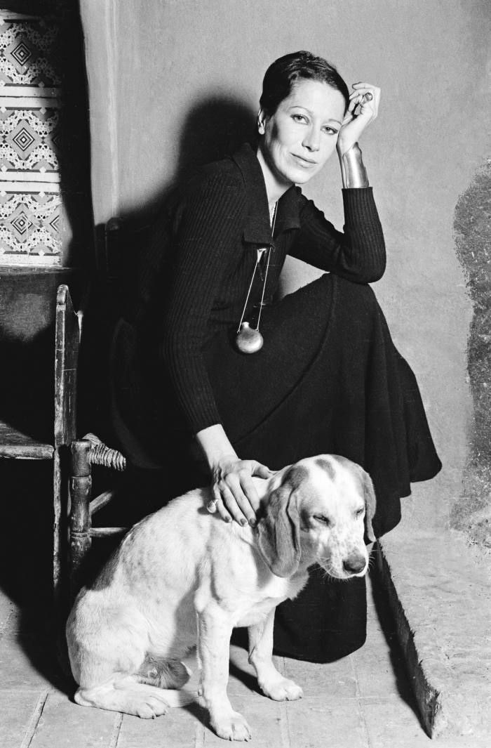 Elsa Peretti photographed in the late 1960s with her dog, wearing her Tiffany Bottle pendant and Bone cuff