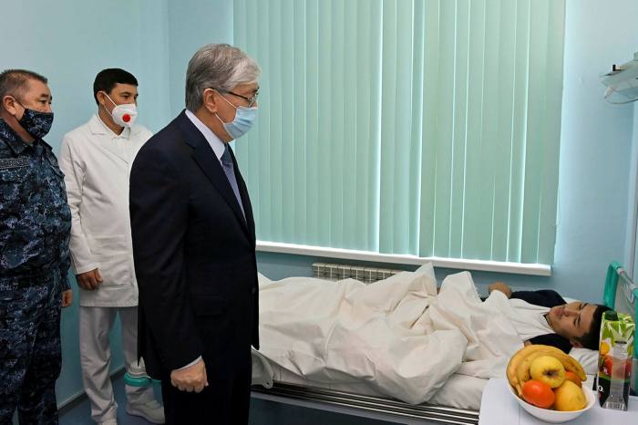 Kazakhstan’s president Kassym-Jomart Tokayev speaks to a man who was injured during recent civil unrest at a hospital in Almaty, Kazakhstan