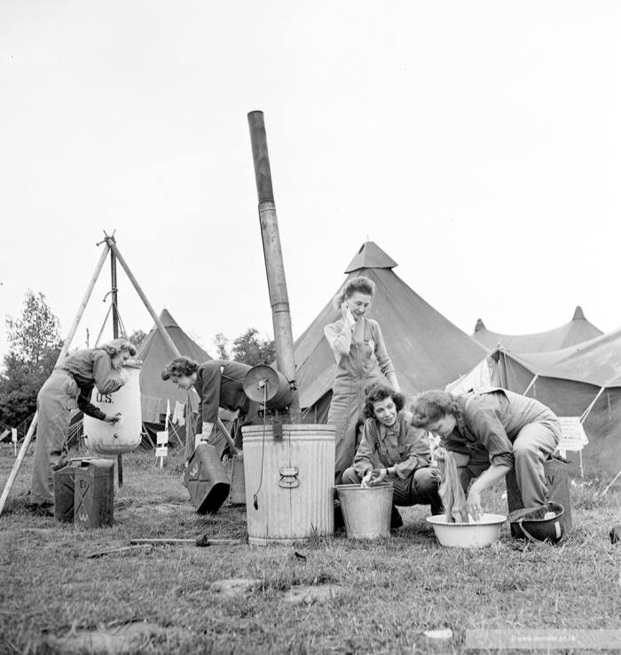 Nurses wash in basins outside their tents