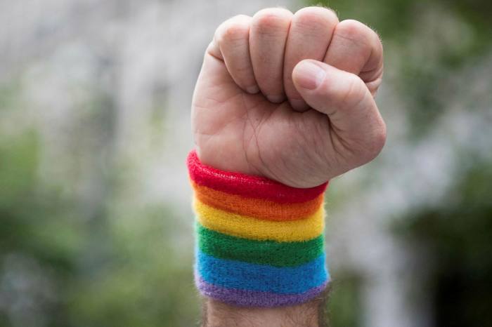 A man raises a fist while marching along the parade route during the San Francisco Pride parade