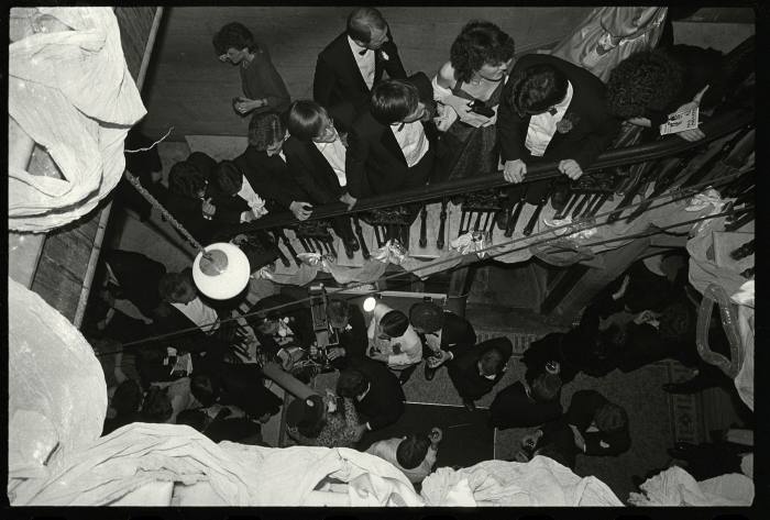 Young men in black tie crowding a staircase 