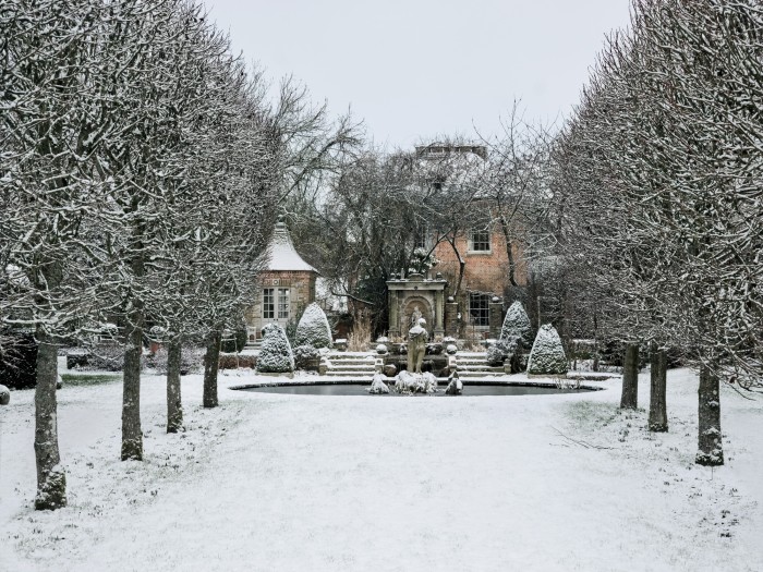 An avenue of pleached limesin the garden of a Hampshire Tudor manor