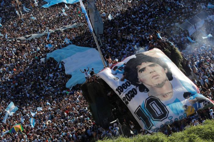 Aficionados argentinos con una pancarta de Diego Maradona celebran su victoria en Buenos Aires