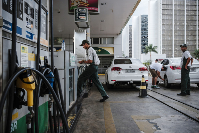 Attendants assist customers at a Petrobras petrol station in Brasilia, Brazil, on Sunday May 7 2017