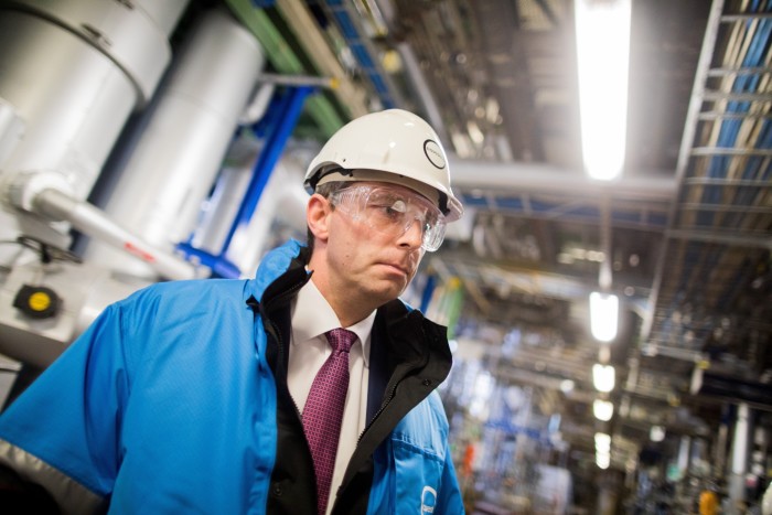 Markus Steilemann, wearing blue high vis jacket over his suit and hard hat and protective glasses
