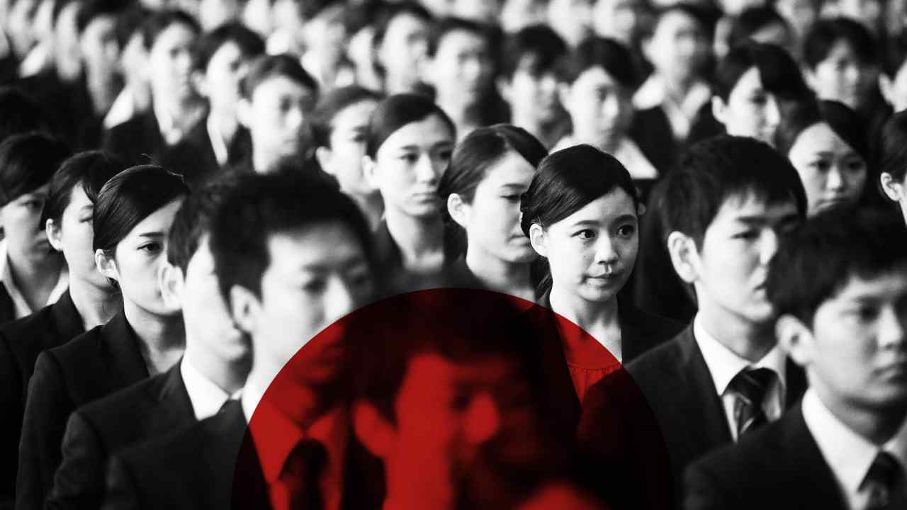 Black and white photo of rows of smartly dressed young Japanese people with a red circle overlaid on the image