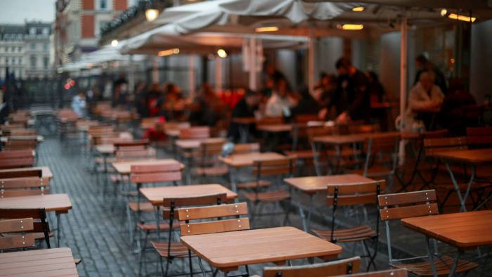 Empty tables are seen at an outdoor seating area in London