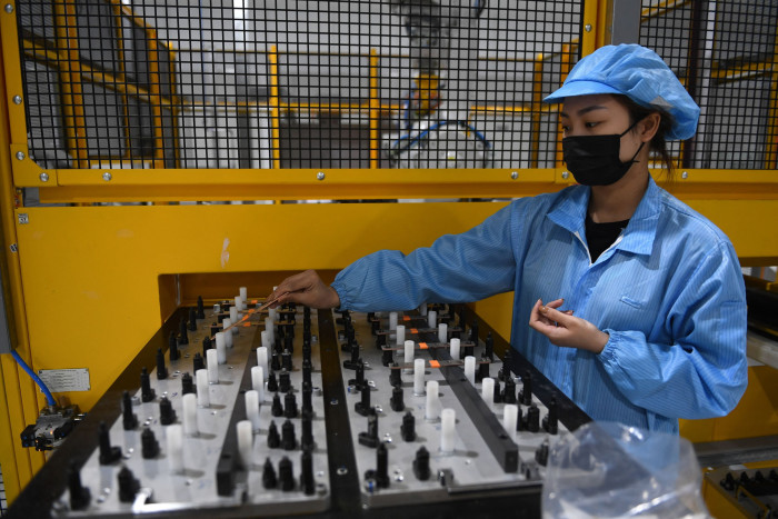 עובד מרכיב סוללת מכונית חשמלית במפעל הרכב החשמלי של VinFast בהיפונג, וייטנאם, באפריל