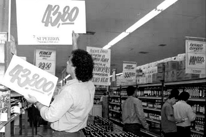 Um homem derruba placas mostrando os preços das mercadorias em um supermercado em 1993