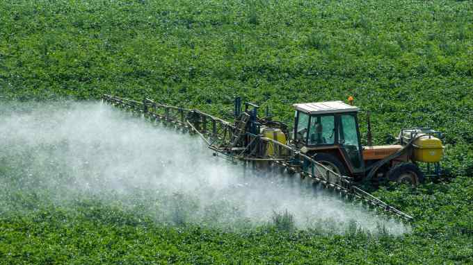A farmer sprays pesticides