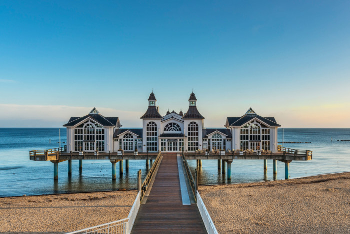 A decorated seaside pier with a bright blue sky behind
