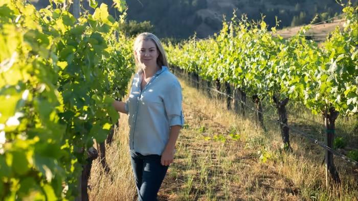 Penanam wain Jasmine Hirsch berdiri di sebelah pokok anggur di ladang anggurnya di San Francisco.