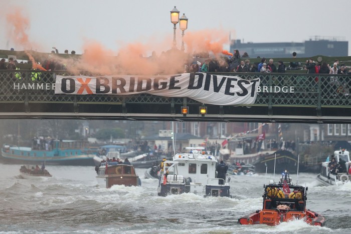 Oxford and Cambridge student environmental activists protest on Hammersmith Bridge in London during a boat race 