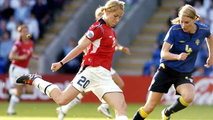 Professional women football players in action, competing for possession and control of the ball