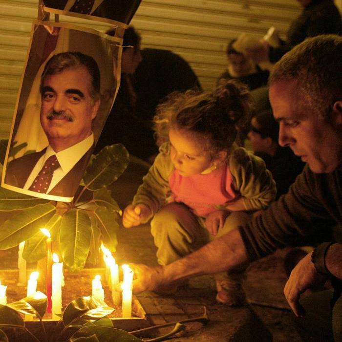 A Lebanese father and his daughter light a candle outside the mansion of assassinated former Lebanese premier Rafiq Hariri in Beirut in 2005