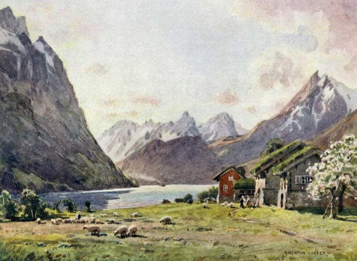 View of a fjord with a lone farmhouse and a pasture in the foreground