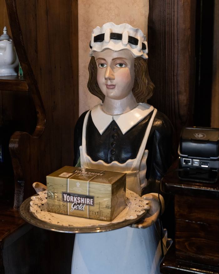 A statuette of a waitress holding a tray bearing a box of Yorkshire Gold tea at Miss Marple’s tearoom in Sassafras
