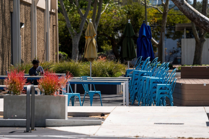 A person sits outside of a building on a Google campus in Mountain View, California