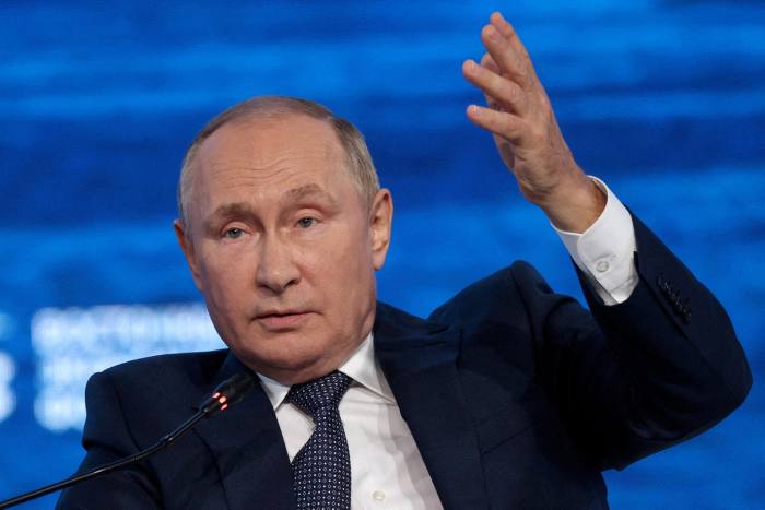 Vladimir Putin gestures at an event