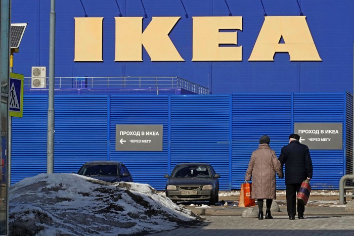 An elderly couple walking towards an Ikea store in Moscow