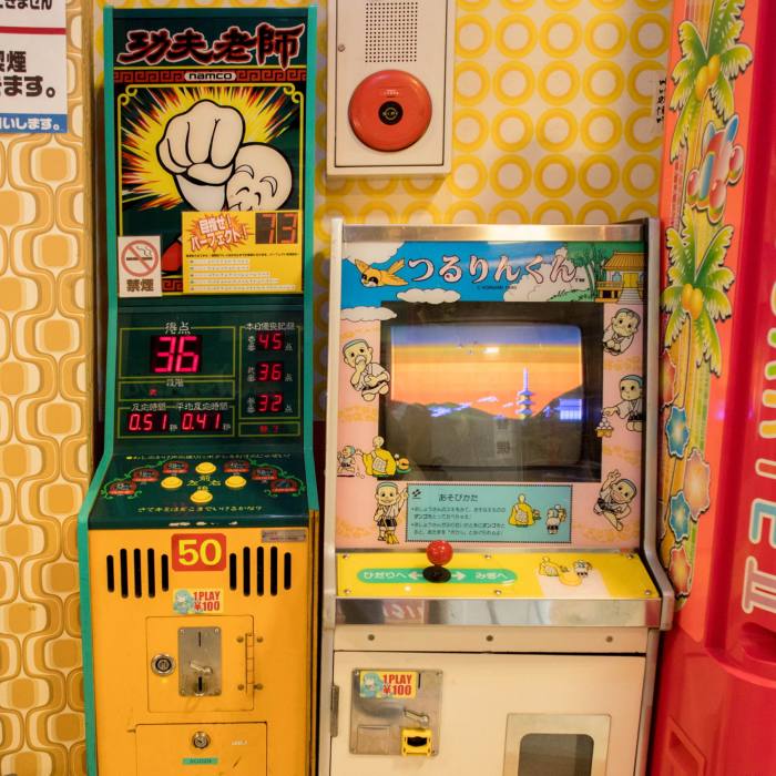 Two retro video games against yellow 70s style wallpaper at the Mikado Game Center