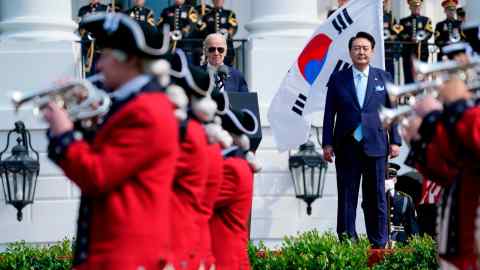 Joe Biden y Yoon Suk Yeol de Corea del Sur observan cómo la vieja guardia Fife and Drum Corps del Ejército de EE. UU. pasa por el jardín sur de la Casa Blanca.