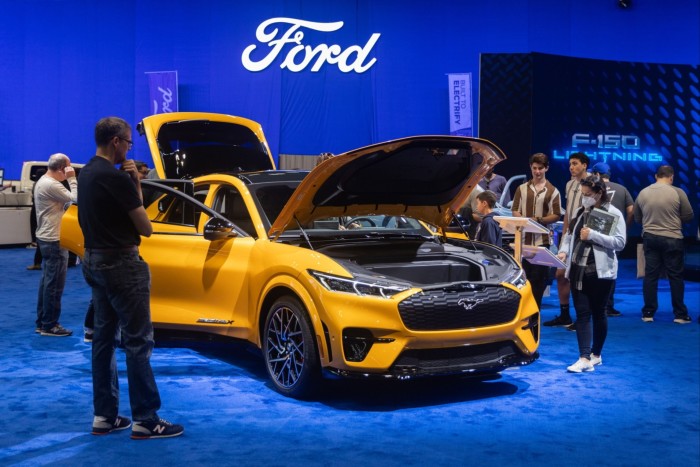 Los asistentes a una exhibición de autos ven un Ford Mustang Mach-E